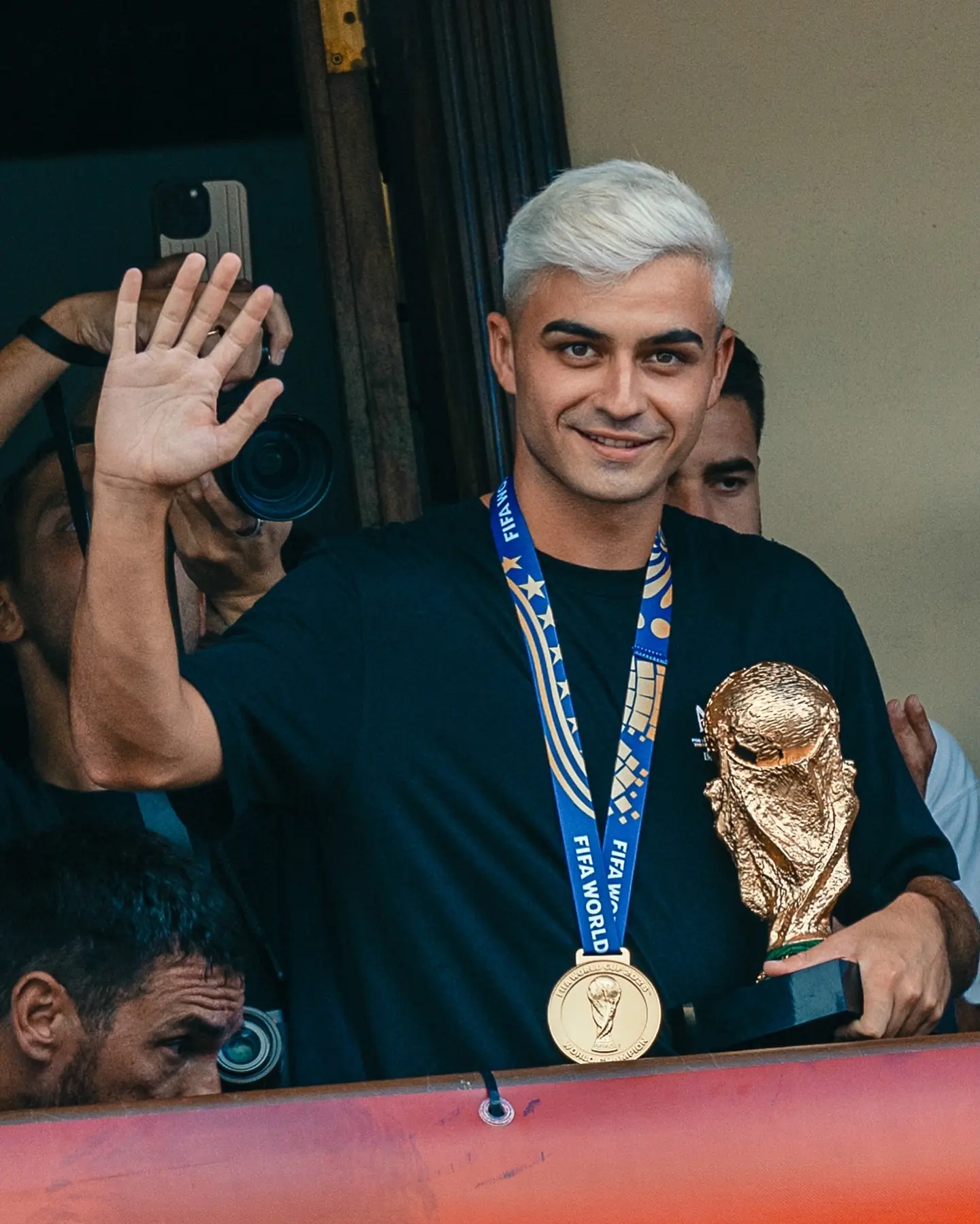 Deportista saluda con una medalla y un trofeo durante una celebración