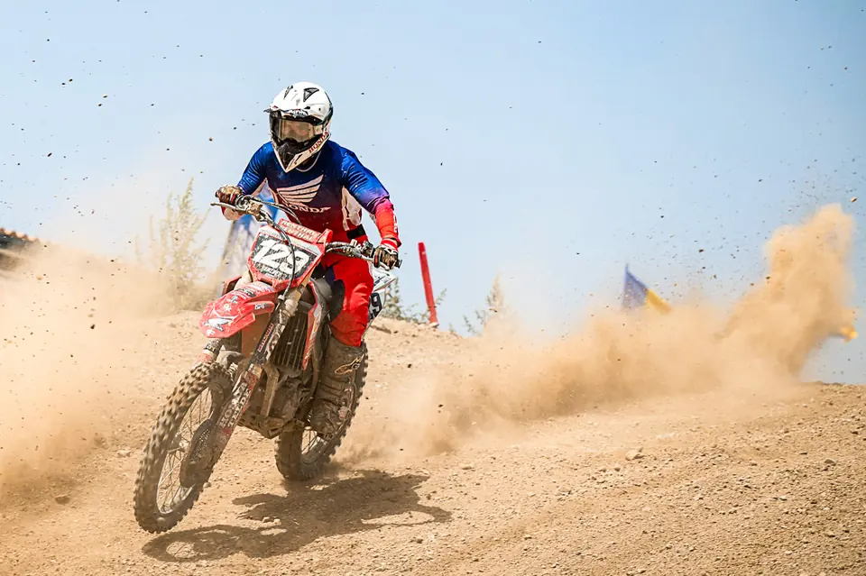 Piloto de motocross levantando una nube de polvo