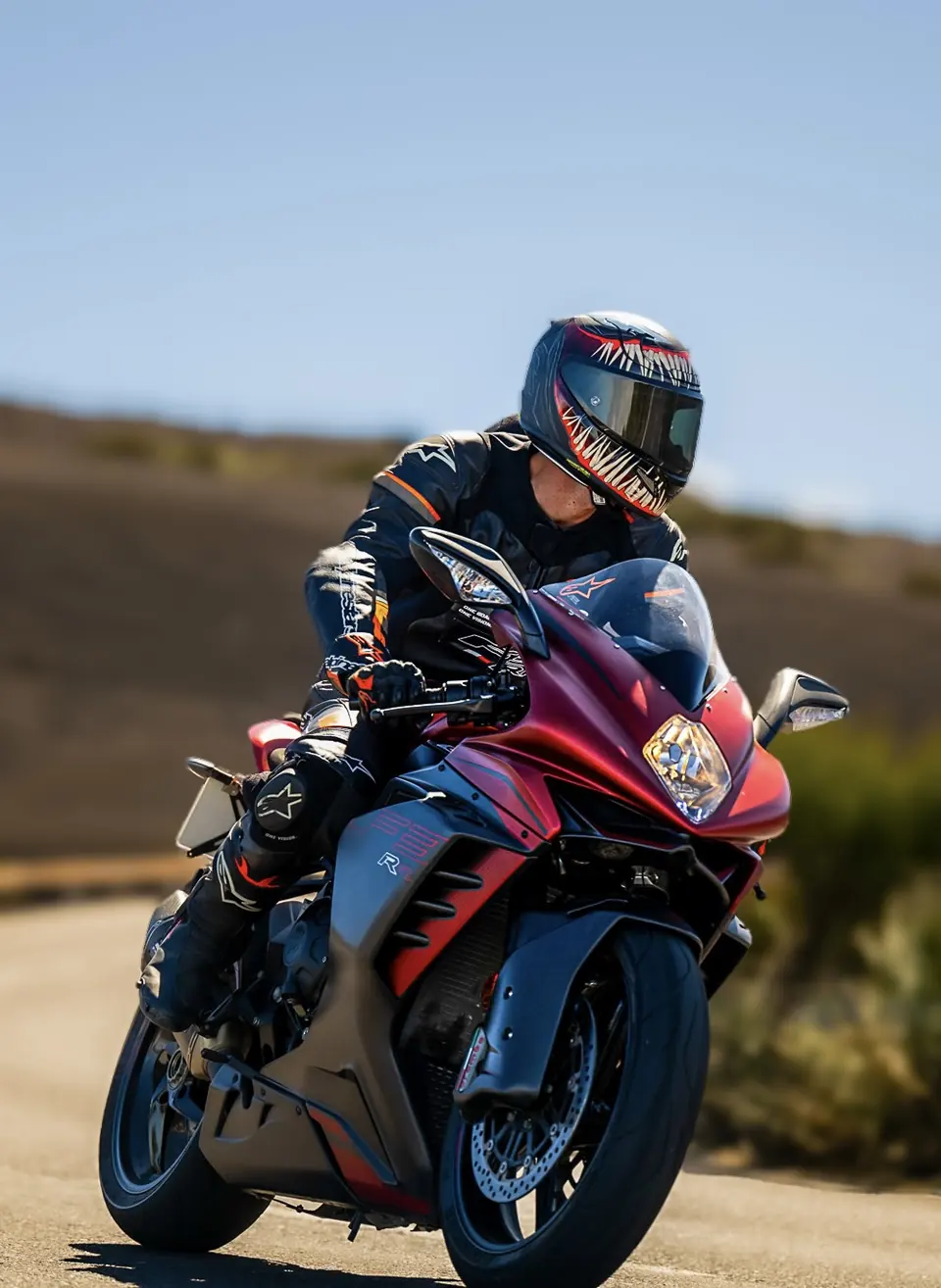 Motorista con moto deportiva roja y azul en carretera